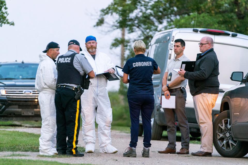 Investigators gather in front of the scene of a stabbing in Weldon, Saskatchewan, Sunday, Sept. 4, 2022.