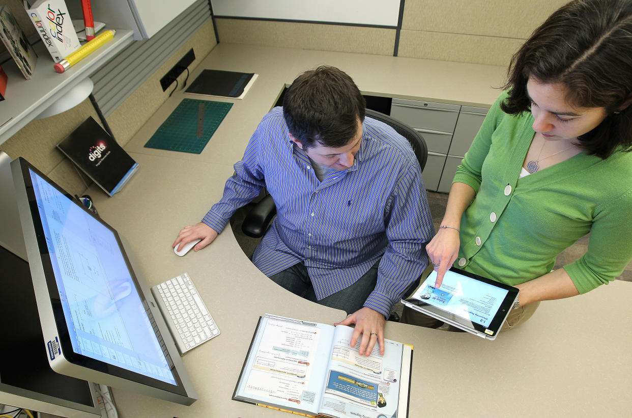 BOSTON, MA - JANUARY 24: Pearson designer Brian Reardon uses Apple's textbook publishing tools to work on a geometry text, on Tuesday, Jan. 24, 2012.  Working with him is Vicky K. Shen, manager of secondary mathematics. (Photo by Pat Greenhouse/The Boston Globe via Getty Images)