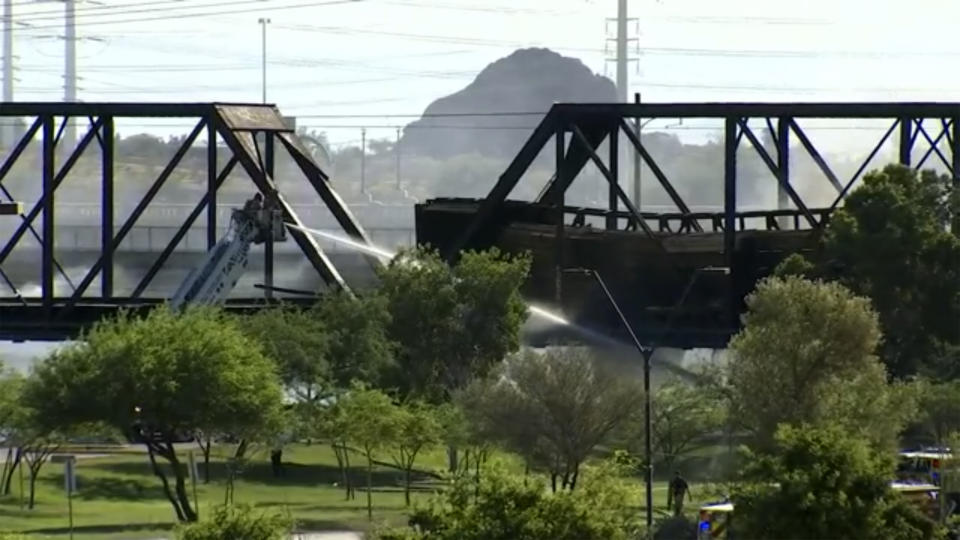 Smoke fills the sky at the scene of a train derailment in Tempe, Ariz., on Wednesday, July 29, 2020. Officials say a freight train traveling on a bridge that spans a lake in the Phoenix suburb derailed and set the bridge ablaze and partially collapsing the structure. There were no immediate reports of any leaks. (AP Photo/Pool)