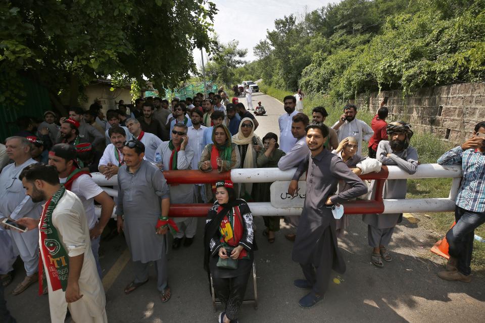 Supporters of Pakistan's former Prime Minister Imran Khan's party gather outside his residence in Islamabad, Pakistan, Monday, Aug. 22, 2022. Pakistani police have filed terrorism charges against Khan, authorities said Monday, escalating political tensions in the country as the ousted premier holds mass rallies seeking to return to office. (AP Photo/Anjum Naveed)