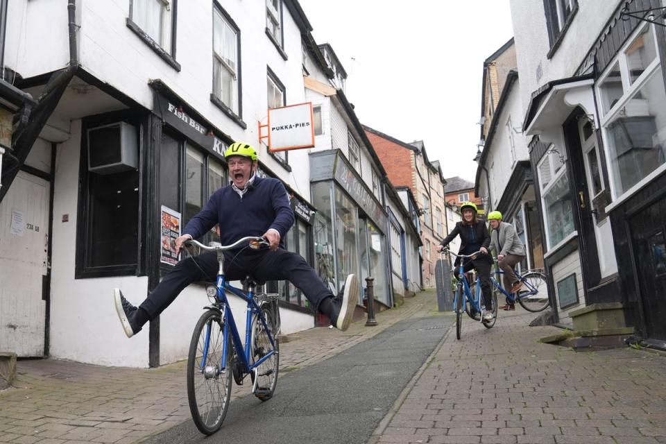 Sir Ed rides a bike during a visit to Knighton, Wales (Jacob King / PA Wire)