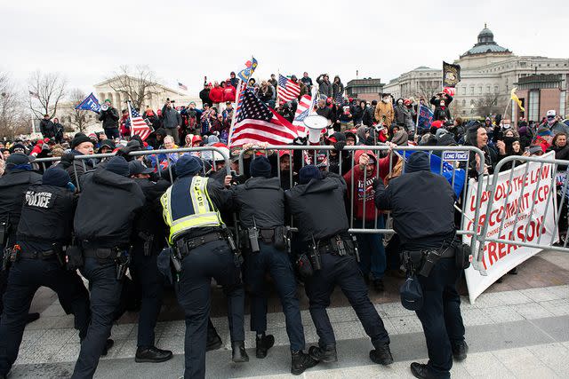 Graeme Sloan/Bloomberg via Getty Pro-Trump rioters charge a police barricade at the U.S. Capitol on Jan. 6, 2021