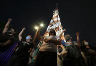 Employees and supporters of ABS-CBN raise their clenched fist as they sing outside their headquarters in Quezon City, Philippines Friday July 10, 2020. Philippine lawmakers voted Friday to reject the license renewal of the country's largest TV network ABS-CBN, shutting down a major news provider that had been repeatedly threatened by the president over its critical coverage. (AP Photo/Aaron Favila)