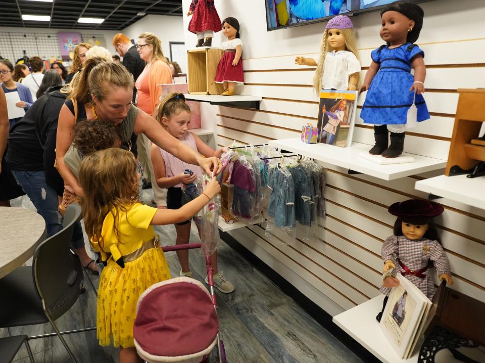 Sue Farreri and daughters Alicia and Cecelia look over the racks of American Girl doll clothes at the new Girl AGain boutique at the Palisades Center Mall. Yes She Can, of Westchester and BRIDGES, Rockland County's independent living center, opens a branch of Girl AGain, a resale store for American Girl dolls at the Palisades Center Mall in West Nyack. Tuesday, August 29, 2023.