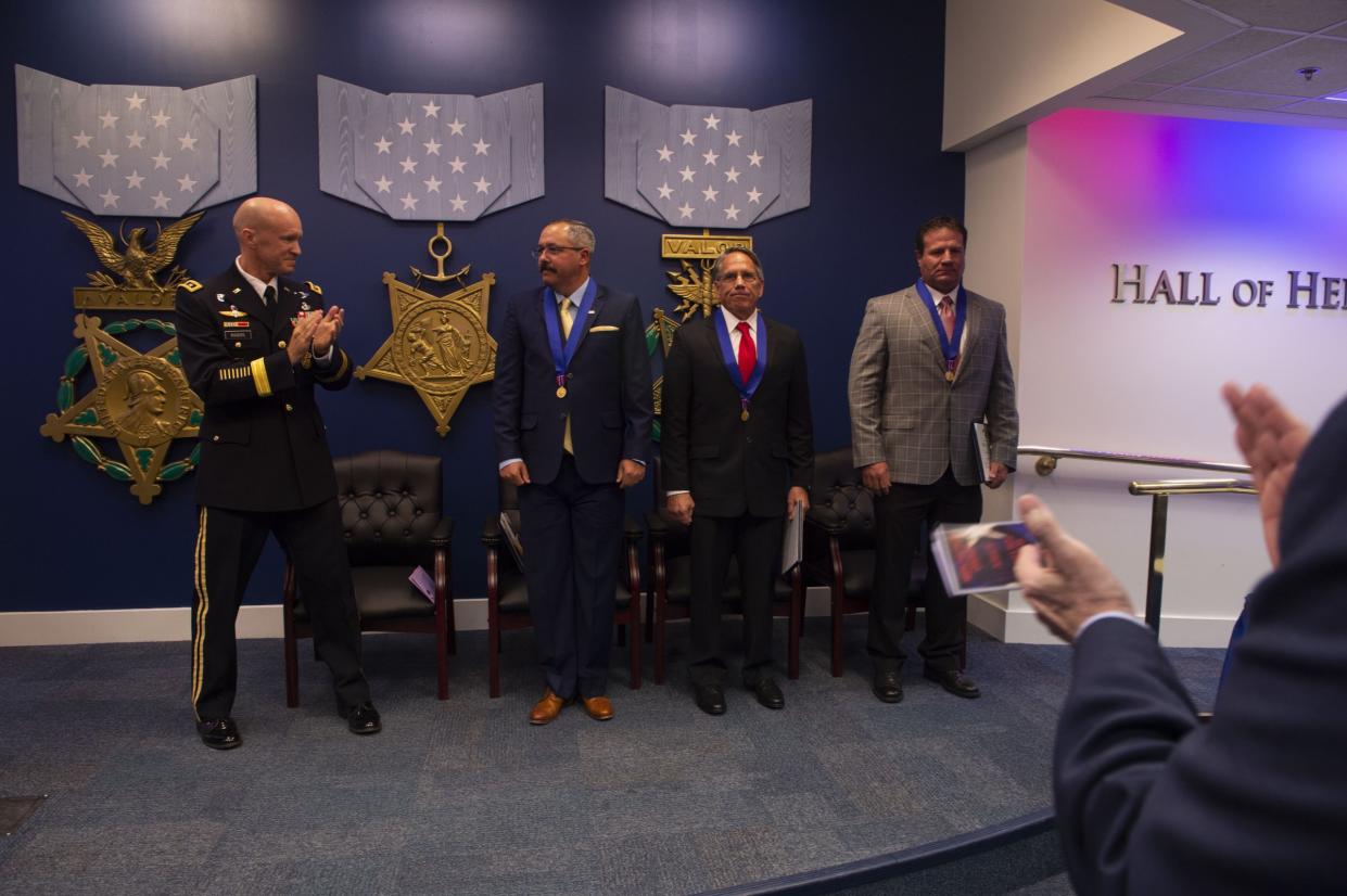 Army Lt. Gen. Darsie Rogers, Defense Threat Reduction Agency deputy director for combat support, applauds after awarding the Medal of Valor to Michael Anthony Dunne, William Timothy Nix and Brandon Ray Seabolt at the Pentagon, Aug. 14, 2018.