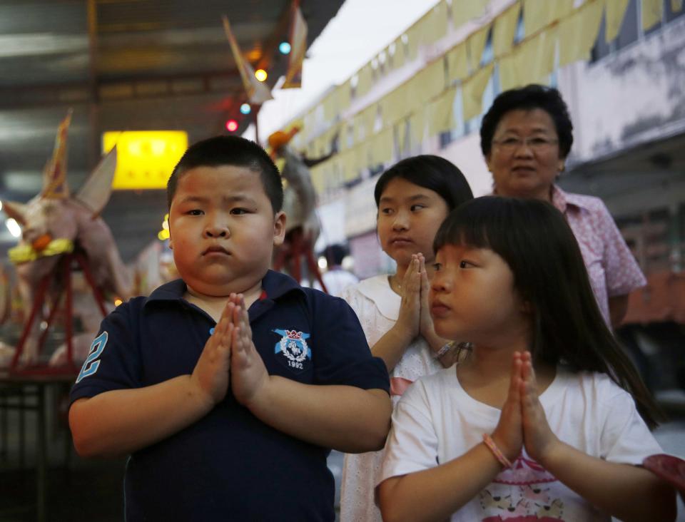 Children pray during the Hungry Ghost festival in Kuala Lumpur