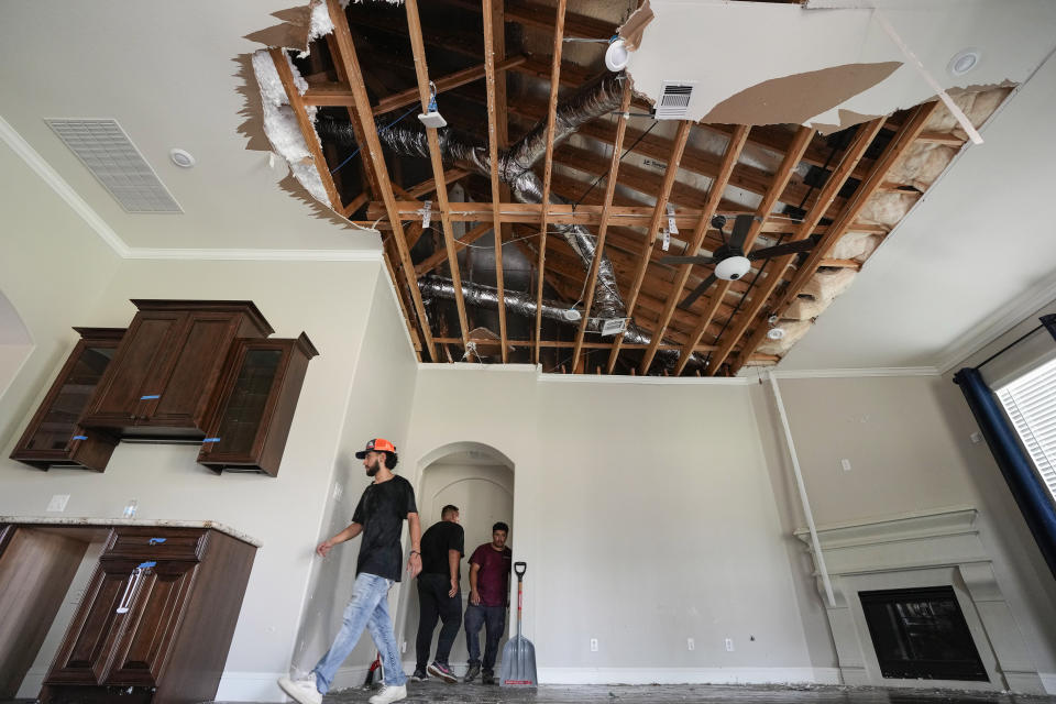 A restoration crew works in a home while cleaning up storm damage on Sunday, May 19, 2024, in Cypress, Texas. The suburban Houston area of Bridgeland suffered major damage last week after a line of powerful storms, that included a confirmed tornado, swept through the area. (Brett Coomer/Houston Chronicle via AP)