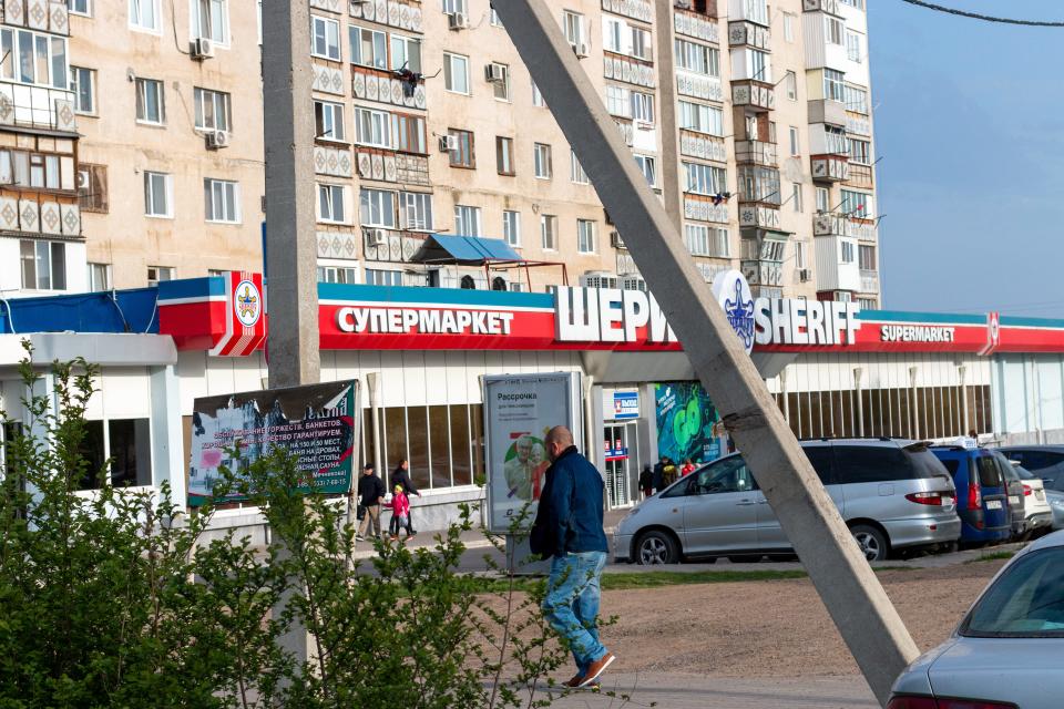 man walking in front of supermarket