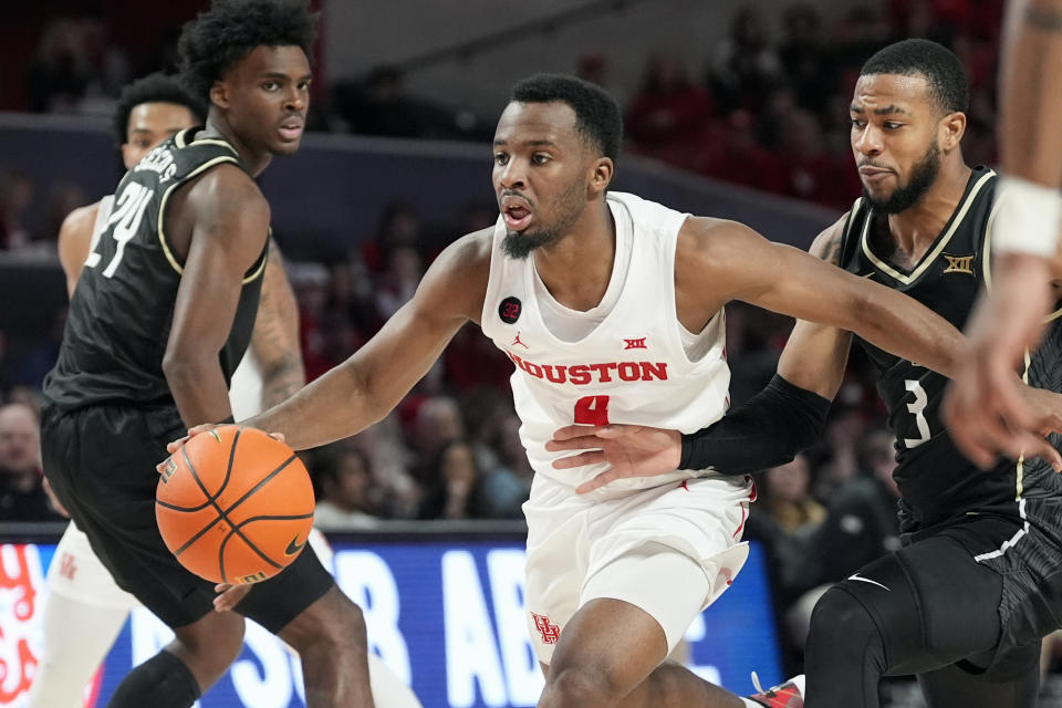 Houston's L.J. Cryer (4) is fouled by Central Florida's Darius Johnson (3) during the second half of an NCAA college basketball game Saturday, Jan. 20, 2024, in Houston. (AP Photo/David J. Phillip)