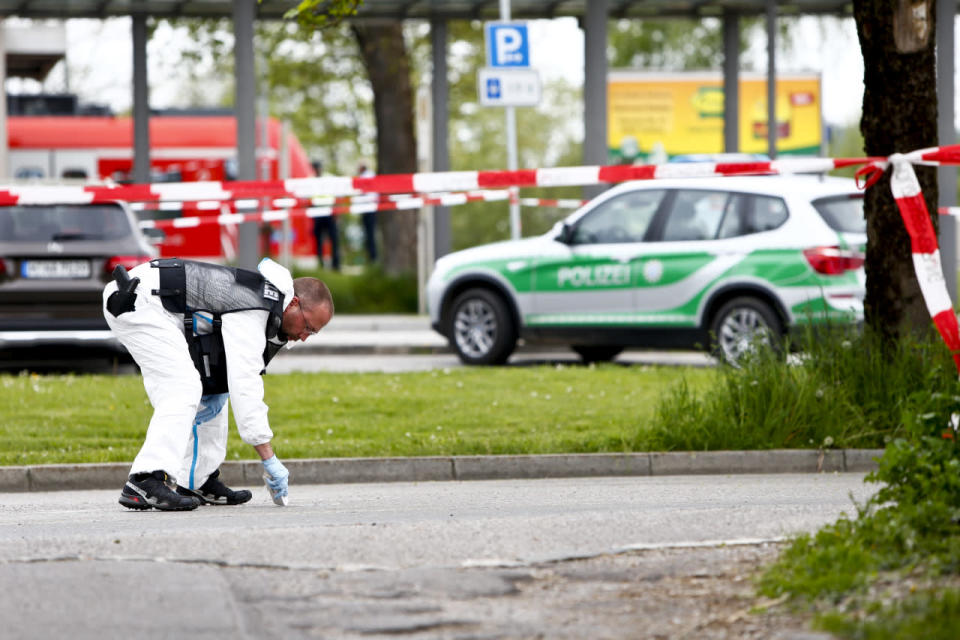 A police officer looks for evidence at the train station, after an attack in Grafing, Germany, May 10, 2016. (REUTERS/Michaela Rehle)