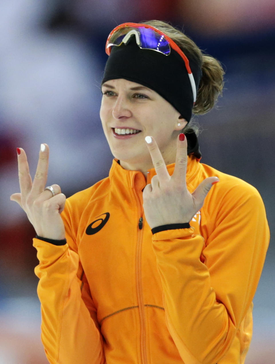 La holandesa Ireen Wust muestra tres dedos en cada mano para señalar la conquista de su tercer oro olímpico tras los 3.000 metros del patinaje de velocidad en los Juegos de Sochi, el domingo 9 de febrero de 2014. (AP Foto/Matt Dunham)