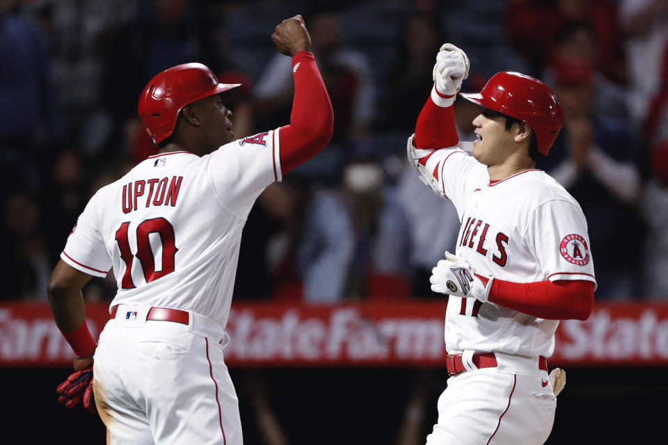 Los Angeles Angels' Shohei Ohtani, right, celebrates his two-run home run with Justin Upton during the fifth inning against the Detroit Tigers in a baseball game in Anaheim, Calif., Friday, June 18, 2021. (AP Photo/Alex Gallardo)