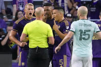 Orlando City players, from back left, Orlando City defender Robin Jansson, defender Antonio Carlos and midfielder Cesar Araujo (5) dispute a ruling with referee Allen Chapman, center, as Atlanta United defender Andrew Gutman (15) looks on during the first half of an MLS soccer match, Saturday, May 27, 2023, in Orlando, Fla. (AP Photo/John Raoux)