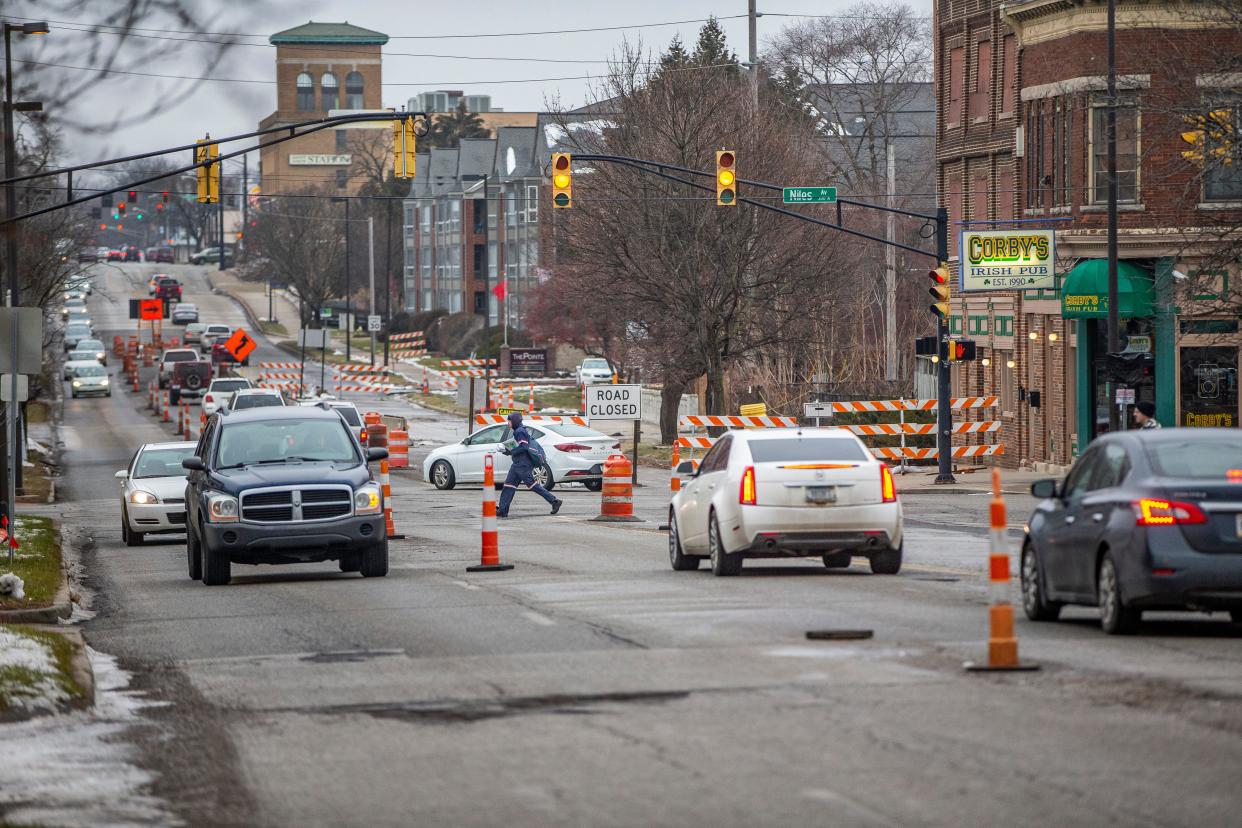 Cars and a postal worker navigate the construction zone traffic on LaSalle Avenue at the Niles Avenue intersection in South Bend.
