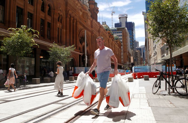 FILE PHOTO: A man carries several shopping bags as he walks along George Street in Sydney