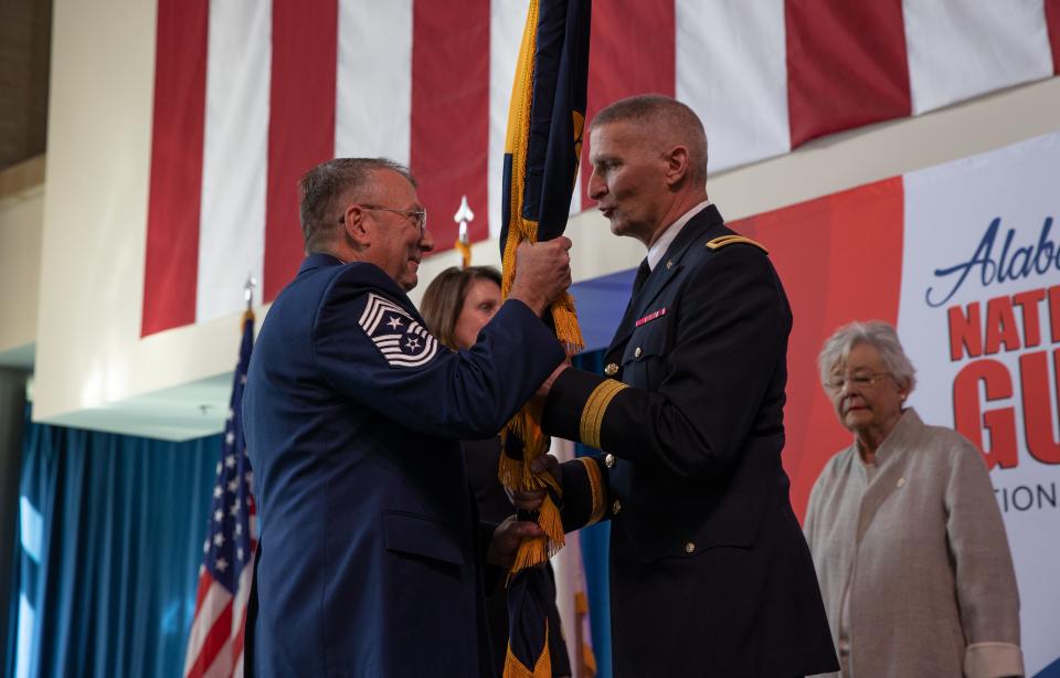 Brig. Gen. David Pritchett incoming Alabama National Guard adjutant general hands the colors to CMSgt David Bullard Alabama National Guard command senior enlisted leader during a change of command ceremony in Montgomery, Ala. on Jan. 5, 2024.