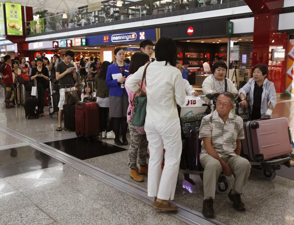 Passengers wait at Hong Kong Airport as flights are cancelled in anticipation of typhoon Usagi