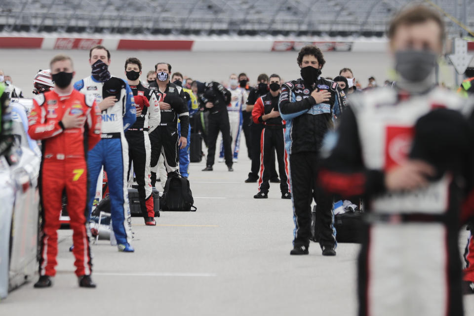 Drivers stand for the national anthem before the Toyota 200 NASCAR Xfinity series auto race Thursday, May 21, 2020, in Darlington, S.C. (AP Photo/Brynn Anderson)