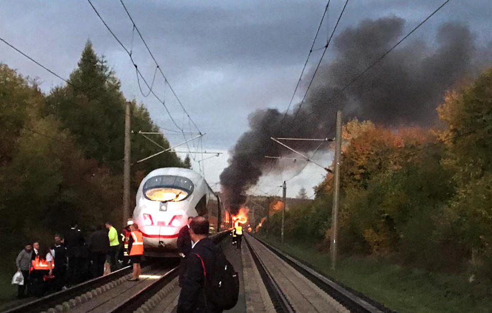 Flames and smoke rise over an ICE train near Montabaur, western Germany, Friday morning, Oct. 12, 2018. Nobody was injured when the high-speed train was evacuated. (Ute Lange/dpa via AP)