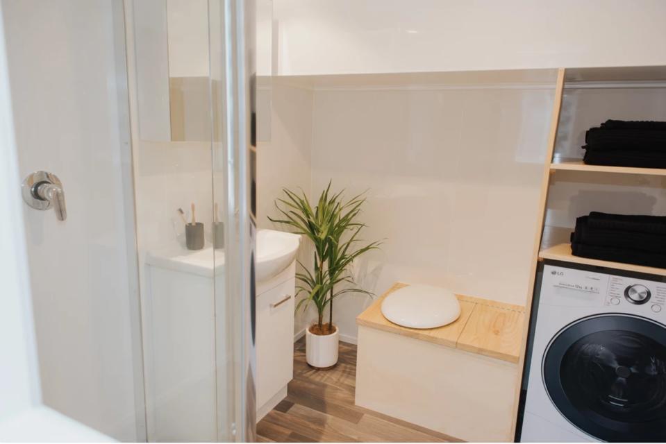 En el lado opuesto de la casa está el baño. Este cuenta con ducha, lavabo, inodoro y lavadora. (Foto: <a href="http://www.buildtiny.co.nz/kahurangi-koinga-tiny-house" rel="nofollow noopener" target="_blank" data-ylk="slk:Build Tiny;elm:context_link;itc:0;sec:content-canvas" class="link ">Build Tiny</a>).