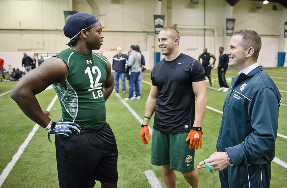 MSU linebackers Greg Jones (left to right) and Eric Gordont share a laugh with MSU linebackers coach Mike Tressel at NFL Pro Day in the Duffy Daugherty Football building Wednesday March 16, 2011 in East Lansing, Michigan.