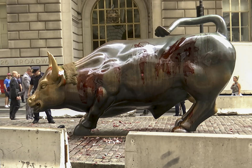 In this freeze frame made from a video stage blood covers the iconic "Charging Bull" statue near Wall Street on Monday Oct. 7, 2019, in New York. Demonstrators say they were protesting against a lack of government action against climate change. (AP Photo/Ted Shaffrey)