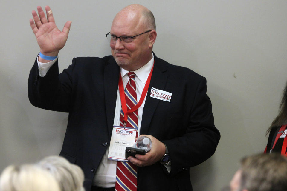 FILE - Mike Brown, an Overland Park, Kan., Republican activist, greets fellow activists from the 2nd Congressional District of eastern Kansas during a state convention, Feb. 11, 2023, in Topeka, Kan. Brown, a conspiracy theorist who lost his primary bid for secretary of state, was named chair of the state party. (AP Photo/John Hanna, File)