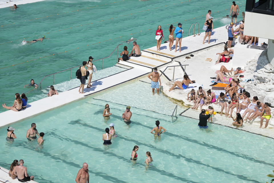 People gather in a and around pools at Bondi Beach in Sydney, Tuesday, Sept. 19, 2023. Sydney has experienced its first total fire ban in almost three years and several schools on the New South Wales state South Coast were closed because of a heightened wildfire danger with extraordinarily high temperatures across southeast Australia. (AP Photo/Rick Rycroft)