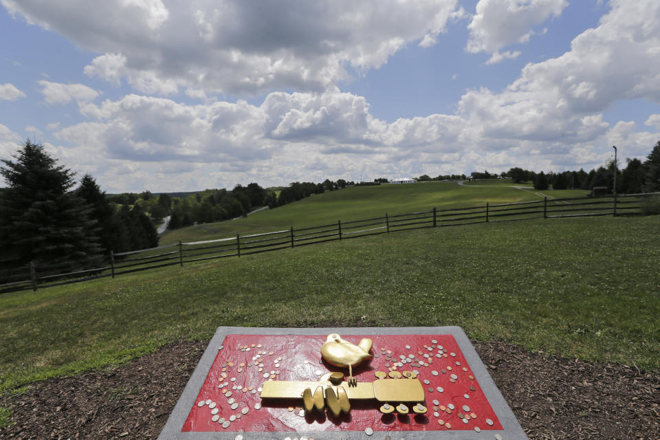 A plaque marks the site of the 1969 Woodstock Music and Arts Fair, Wednesday, July 24, 2019 in Bethel, N.Y. Woodstock will be celebrated on its 50th anniversary, but it won't be your hippie uncle's trample-the-fences concert. While plans for a big Woodstock 50 festival collapsed after a run of calamities, the bucolic upstate New York site of the 1969 show is hosting a long weekend of events featuring separate shows by festival veterans like Carlos Santana and John Fogerty. (AP Photo/Seth Wenig)