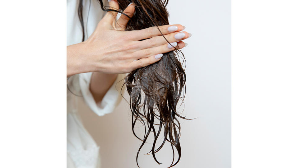 woman applying conditioner to just midshafts and ends