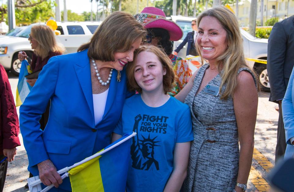 U.S. Speaker of the House Nancy Pelosi hugs Kiki Casale, who gave her Ukrainian flags before she spoke about the infrastructure bill and how it will be used to deal with aging infrastructure, on Saturday in Delray Beach. At right is Kaki's mom, Delray Beach Commissioner Juli Casale.