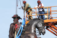 Crews attach straps to the statue Confederate General J.E.B. Stuart on Monument Avenue, Tuesday, July 7, 2020, in Richmond, Va. The statue is one of several that will be removed by the city as part of the Black Lives Matter reaction. (AP Photo/Steve Helber)