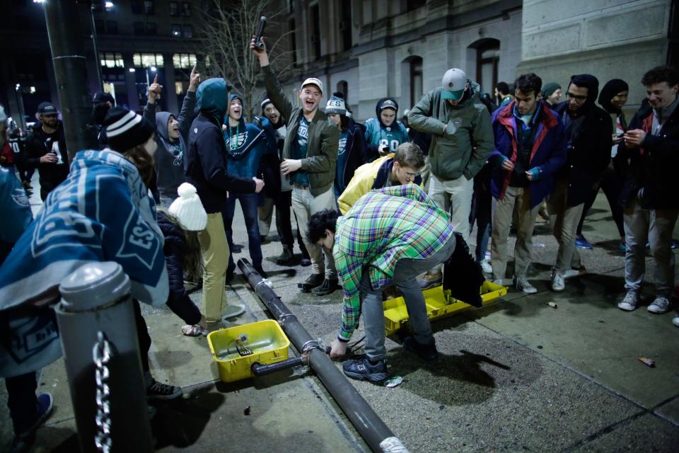 <p>People break a traffic light while celebrating the Philadelphia Eagles’ victory in Super Bowl LII game against the New England Patriots on February 4, 2018 in Philadelphia, Pennsylvania..(Photo by Eduardo Munoz Alvarez/Getty Images) </p>