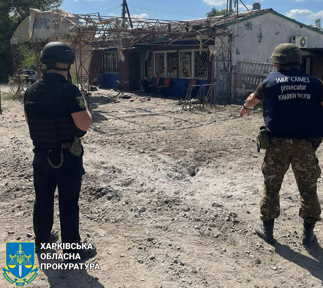 In this handout photograph taken and released by the Office of the Prosecutor General of Ukraine on August 26, 2023, war crime prosecutors work at the site of a shelling in the village of Podoly near Kupiansk, Kharkiv region. (Office of the Prosecutor General)