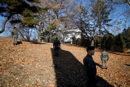 South Korean soldier stand guard next to a spot where a North Korean has defected crossing the border on November 13, as a North Korean guard post (C) is seen at the truce village of Panmunjom inside the demilitarized zone, South Korea, November 27, 2017. REUTERS/Kim Hong-Ji