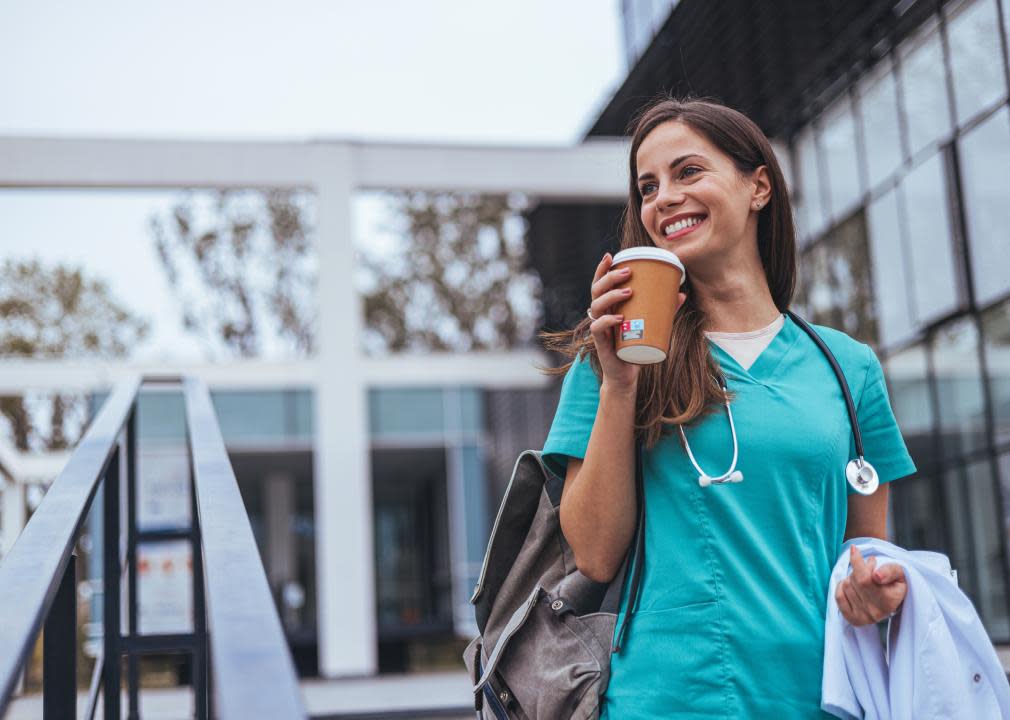 A health care worker leaving a building in uniform.