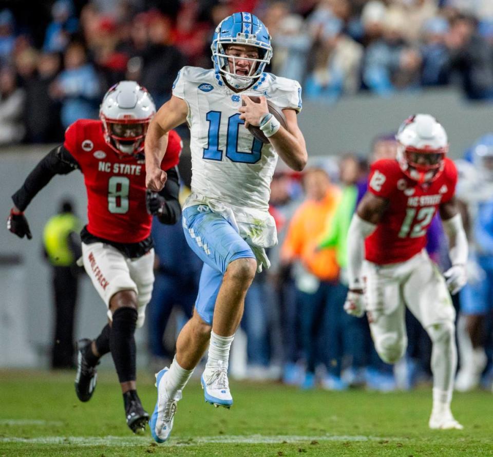 North Carolina quarterback Drake Maye (10) breaks open on a 56-yard gain ahead of N.C. State’s Robert Kennedy (8) and Devan Boykin (12) in the third quarter against N.C. State on Saturday, November 25, 2023 at Carter-Finley Stadium in Raleigh, N.C. Robert Willett/rwillett@newsobserver.com