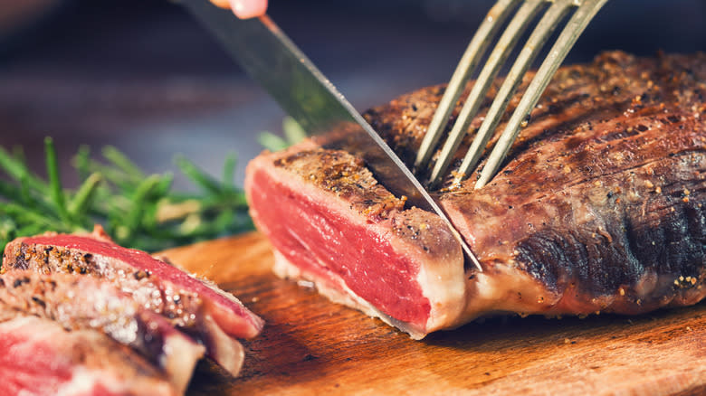 cutting through rare steak