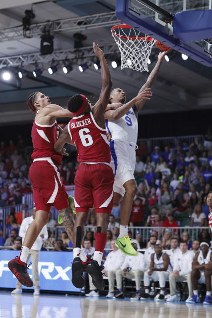 In a photo provided by Bahamas Visual Services, Memphis' Caleb Mills shoots as Arkansas' Layden Blocker (6) and Trevon Brazile defend during an NCAA college basketball game in the Battle 4 Atlantis at Paradise Island, Bahamas, Thursday, Nov. 23, 2023. (Tim Aylen/Bahamas Visual Services via AP)