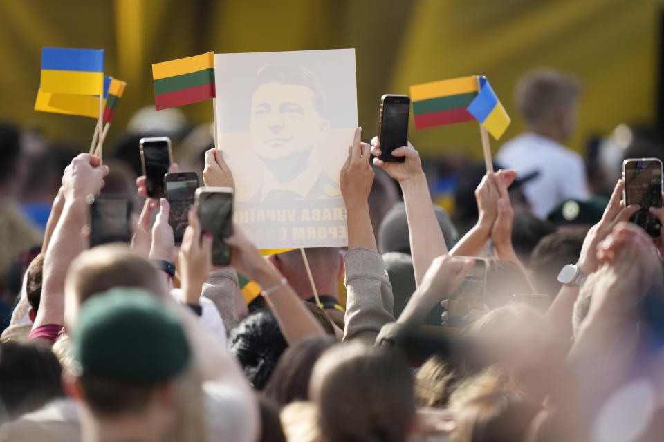 Members of the public wave Ukrainian and Lithuanian flags as they listen to an address by Ukraine's President Volodymyr Zelenskyy during an event on the sidelines of a NATO summit in Vilnius, Lithuania, Tuesday, July 11, 2023. Ukrainian President Volodymyr Zelenskyy on Tuesday blasted as "absurd" the absence of a timetable for his country's membership in NATO, injecting harsh criticism into a gathering of the alliance's leaders that was intended to showcase solidarity in the face of Russian aggression. (AP Photo/Pavel Golovkin)