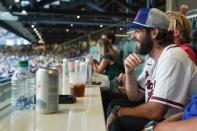 <p>Baseball fan Thomas Rhett cheers on the Atlanta Braves while dressed in Braves gear.</p>