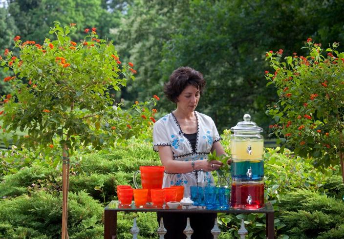 Entertaining during a pandemic is safest when held outdoors. Peggy Noe Stevens adds fresh mint to glasses for the cocktails she's mixed in batches to help avoid extra &quot;hands&quot; on bottles and mixers.