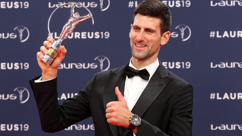 Novak Djokovic poses with his award. (Photo by VALERY HACHE/AFP/Getty Images)