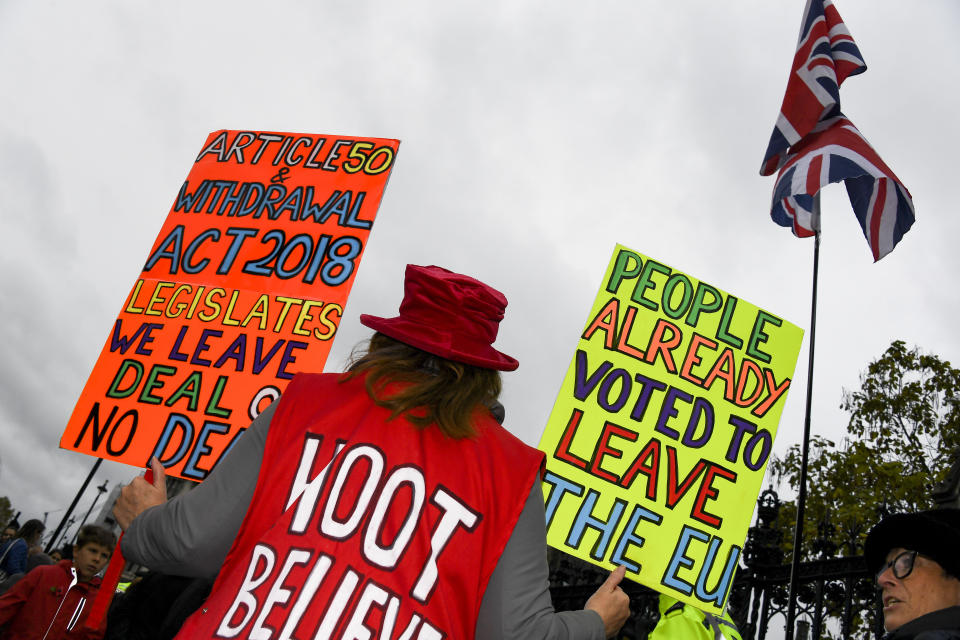 Pro Brexit demonstrators gather outside the Houses of Parliament holding placards and waving Union Flags in London, Monday, Oct. 21, 2019. The European Commission says the fact that British Prime Minister Boris Johnson did not sign a letter requesting a three-month extension of the Brexit deadline has no impact on whether it is valid and that the European Union is considering the request. (AP Photo/Alberto Pezzali)