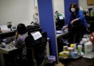 Machiko Nakayama, director of the Tokyo Befrienders call center, and a volunteer handle an incoming call during the spread of the coronavirus disease (COVID-19) continues, in Tokyo