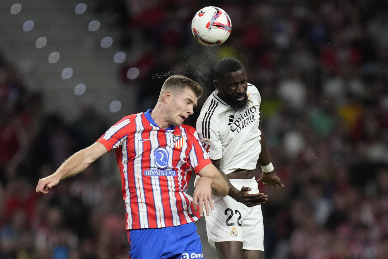 Atletico Madrid's Alexander Sorloth, left, and Real Madrid's Antonio Rudiger jump for the ball during the La Liga soccer match between Atletico Madrid and Real Madrid at the Metropolitano stadium in Madrid, Spain, Sunday, Sept. 29, 2024. (AP Photo/Bernat Armangue)