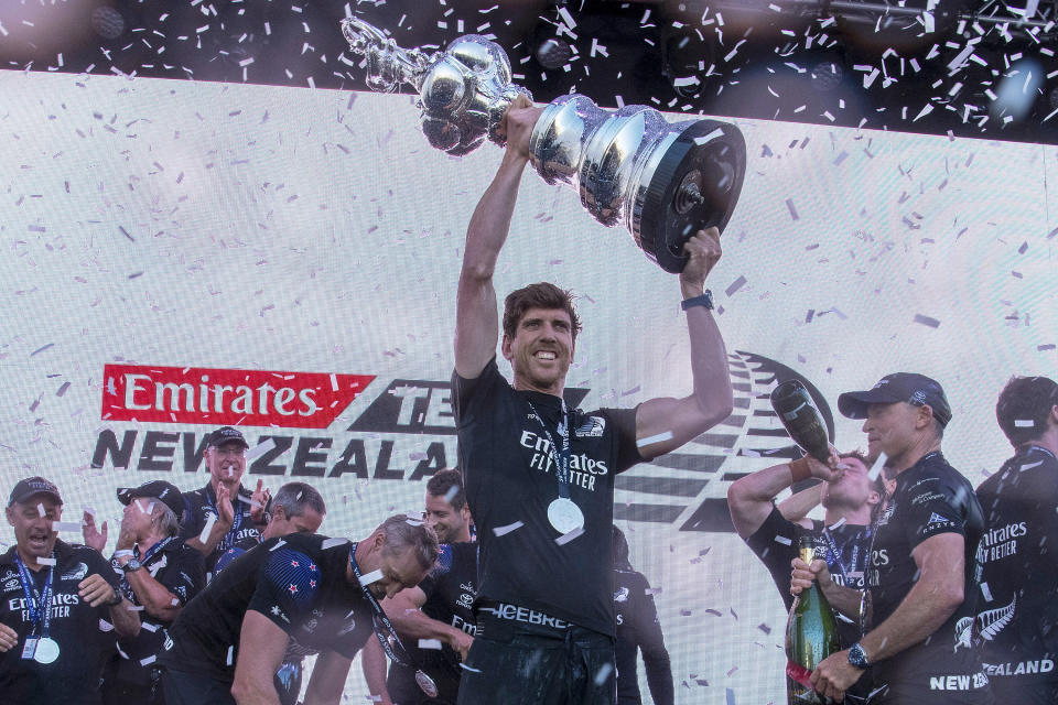 FILE - Emirates Team New Zealand helmsman Peter Burling holds the America's Cup trophy aloft after defeating Italy's Luna Rossa in race ten of the America's Cup on Auckland's Waitemata Harbour, New Zealand on March 17, 2021. Emirates Team New Zealand will defend the America's Cup in Barcelona in 2024, a once unthinkable move that the Kiwis say is needed for their financial survival. The 37th America's Cup match will begin in early Oct. 2024 on the Mediterranean following the challenger trials that will determine Team New Zealand's opponent for the oldest trophy in international sports. (Chris Cameron/Photosport via AP, File)