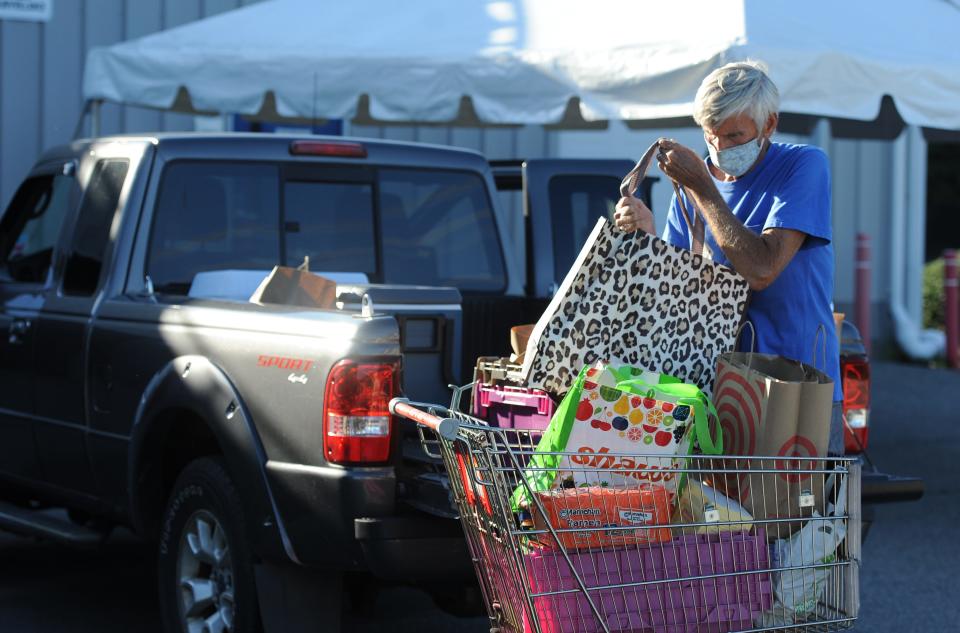 At the Falmouth Service Center in 2020, Jay Burnett, of Falmouth, unloads vegetables and other food items donated to the center at the Falmouth Farmers' Market