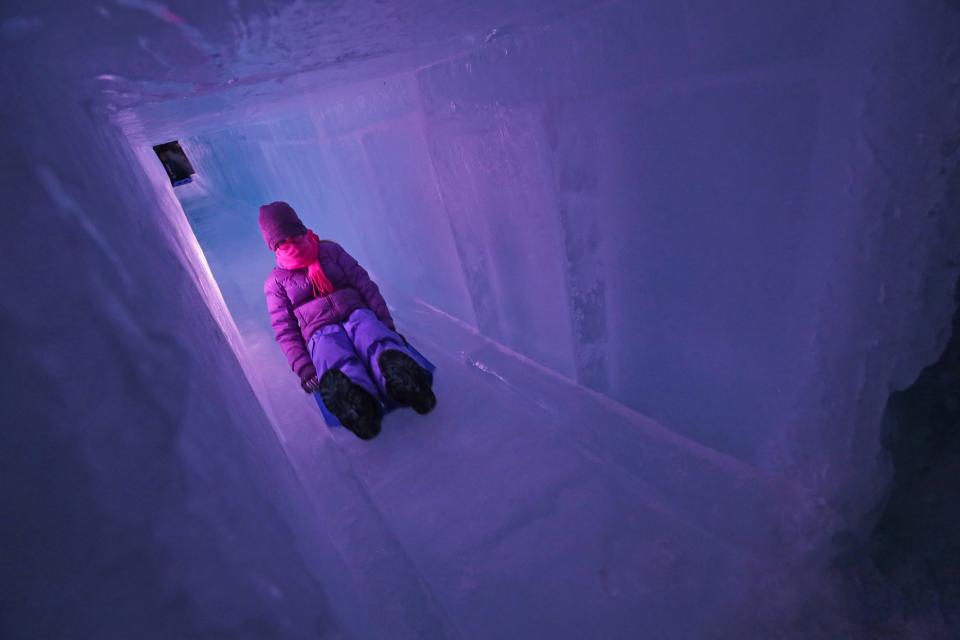 LED lights illuminate an ice tunnel slide in the Lake Geneva Ice Castles display.