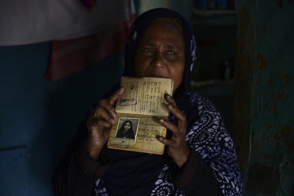 Zainaba Ali, 60, displays her passport as she stands inside her daughter's house where she lives at a colony in the Mattancherry area of Kochi, Kerala, March 6, 2023. The colony is home to mostly low-income families living as 5-6 people in accommodations smaller than 200 square feet per house. Ali spent most of her youth working in the Middle East as a domestic help but has little savings to show for it. She developed arthritis and a slew of other health conditions during those decades of long days and hard work. She was forced to return to India when she was no longer able to work. (AP Photo/ R S Iyer)